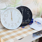 Two clocks on a table with a Pkcell branded cap and batteries in the background. 300mm super mod clocks