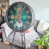Decorative clock with intricate design on a stand in a living room setting metal 600mm wide moving gears