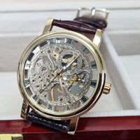 Luxury watch with a brown leather strap and gold casing on a white background