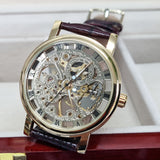 Luxury watch with a brown leather strap and gold casing on a white background