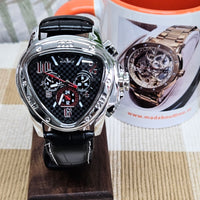 Luxury watch with black strap and detailed face, displayed on a wooden stand with a promotional leaflet in the background.