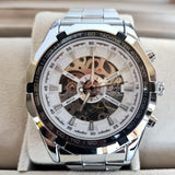 Silver wristwatch with a detailed face on a beige cushion