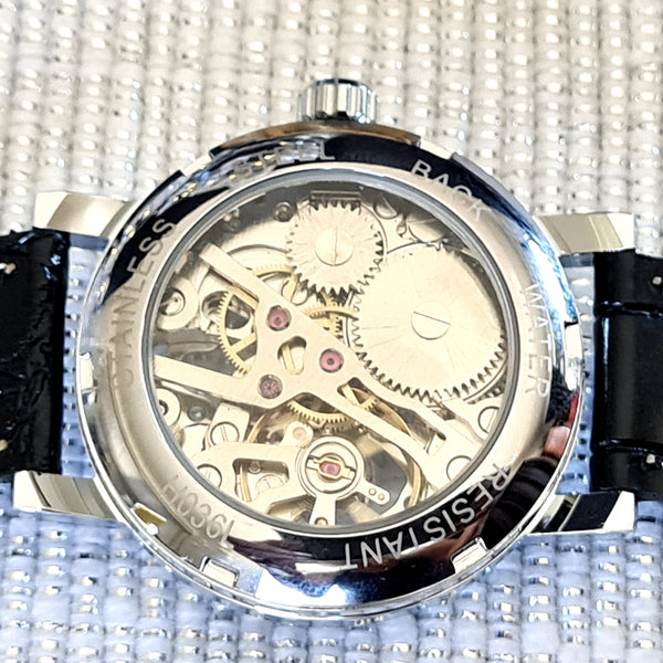 Mechanical watch with visible gears on a textured background