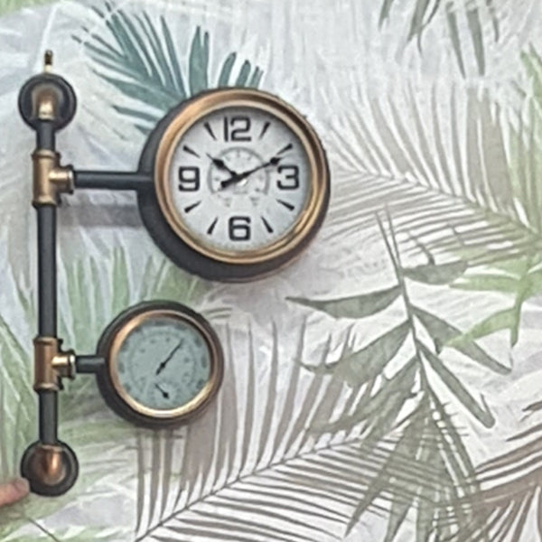 Decorative wall clock with a thermometer on a leafy background