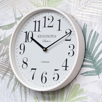 White wall clock with black numbers on a decorative background