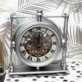Decorative clock with metal frame and visible gears on a patterned surface