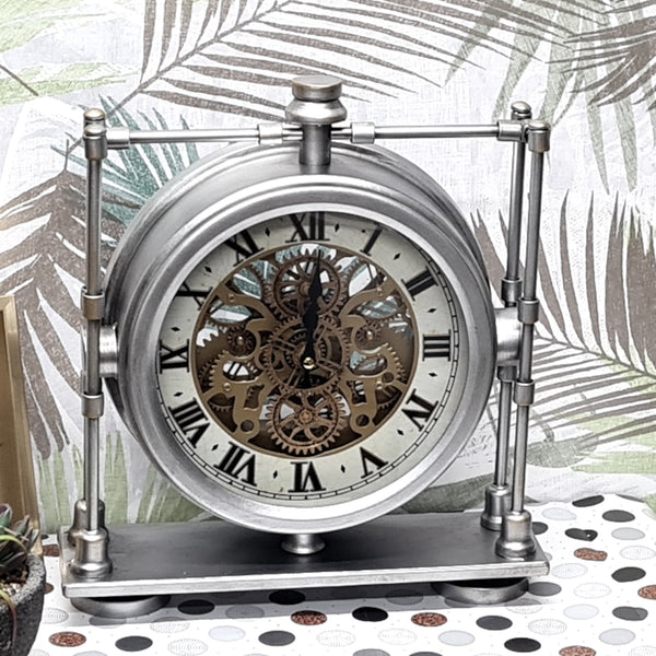 Decorative clock with metal frame and visible gears on a patterned surface