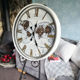 Decorative clock with intricate design on a stand in a cozy living room  Vintage-style clock with intricate design and text highlighting features moving gears metal case glass front 600mm widesetting.