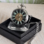 Steampunk-style pocket watch on a black stand with a chain