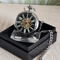 Steampunk-style pocket watch on a black stand with a chain