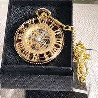 Gold pocket watch with chain in a black box