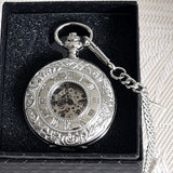 Silver pocket watch with intricate designs on a black background