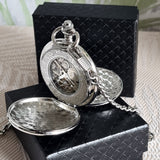 Silver pocket watch with chain on a black box