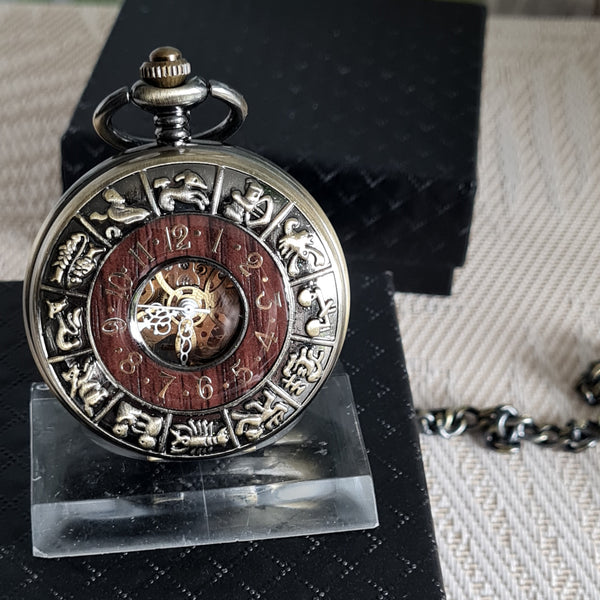 Vintage pocket watch with zodiac symbols on a stand