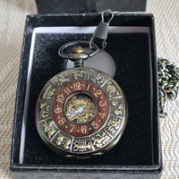 Decorative pocket watch with zodiac symbols in a black box