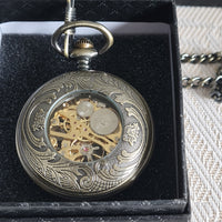 Decorative pocket watch with intricate designs on a black background