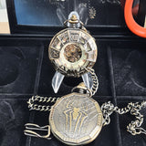 Two pocket watches with detailed designs on a black display stand.