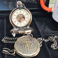 Vintage pocket watch with detailed design on a black background