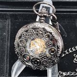 Detailed mechanical pocket watch on a stand with a black background