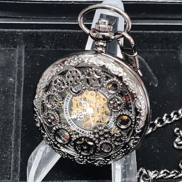 Detailed mechanical pocket watch on a stand with a black background