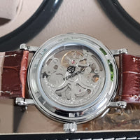 Watch with visible mechanical components and brown leather strap on a neutral background