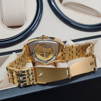 Gold wristwatch with a detailed mechanism on a cushioned surface
