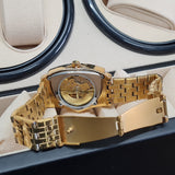 Gold wristwatch with a detailed mechanism on a cushioned surface