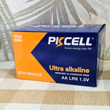 Box of PKCELL ultra alkaline AA LR6 1.5V batteries on a woven mat with a leafy background.